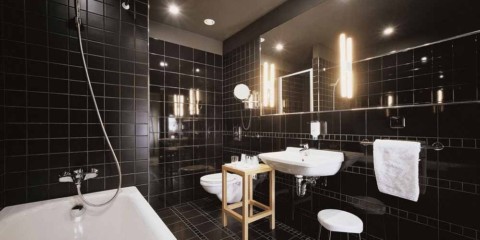 Design moderno bagno piastrelle nere e impianto idraulico bianco