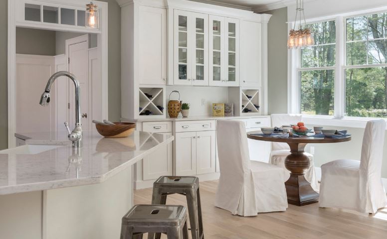 Meubles blancs dans la cuisine-salle à manger d'une maison de campagne