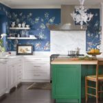 White color of kitchen cabinets, greenish tone of the base of the island - reflected in the floral print of wallpaper