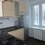 Silver refrigerator near the kitchen window