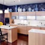 Using dark shades of wallpaper in combination with a light palette of kitchen cabinets