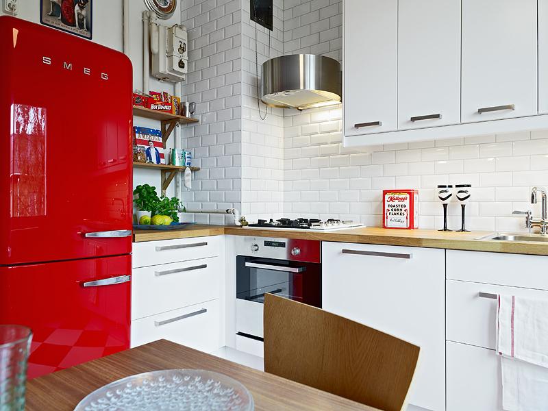 Red refrigerator in the kitchen with white walls