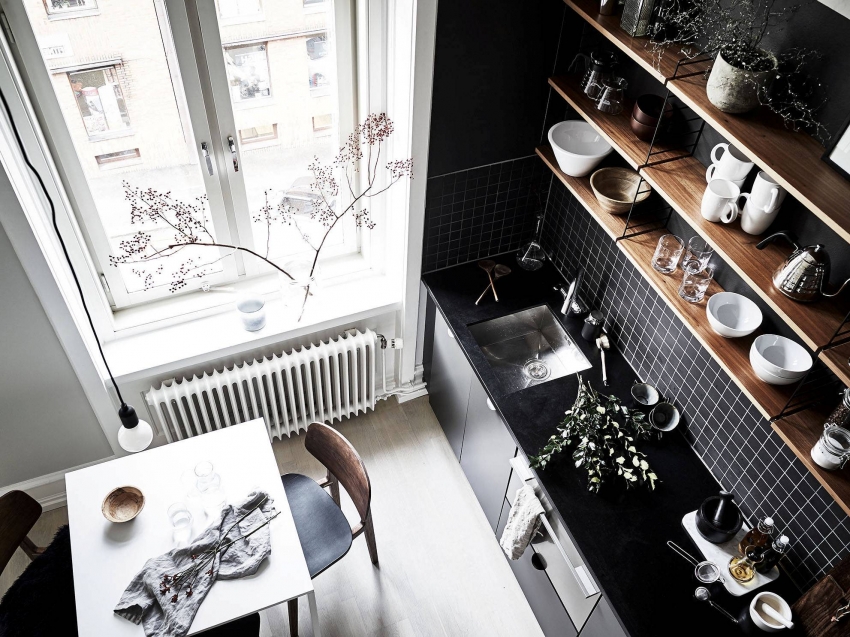 Intérieur de cuisine en noir et blanc avec étagères en bois.