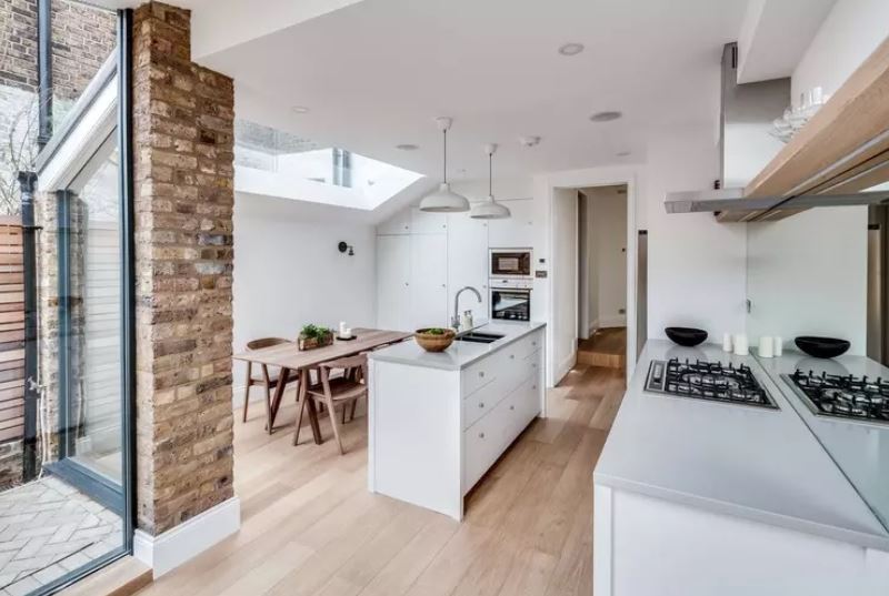 L'intérieur de la cuisine blanche d'une maison de campagne avec un plafond bas