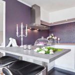 Luxurious purple embossed wallpaper has become a decoration and accent of the kitchen with a snow-white system of cabinets