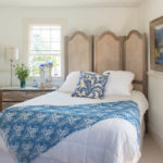 Screen behind the head of the bed in the bedroom of the rural house