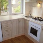 Small kitchen with a sink in the corner near the window