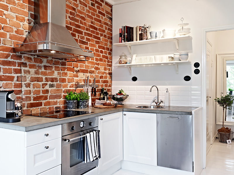 Mur de briques à l'intérieur d'une cuisine blanche