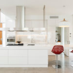 Two red chairs in a white kitchen