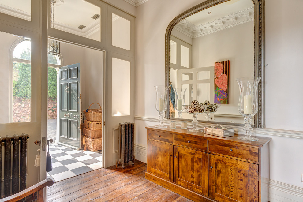 Grand miroir au-dessus d'une commode en bois dans un hall d'entrée spacieux