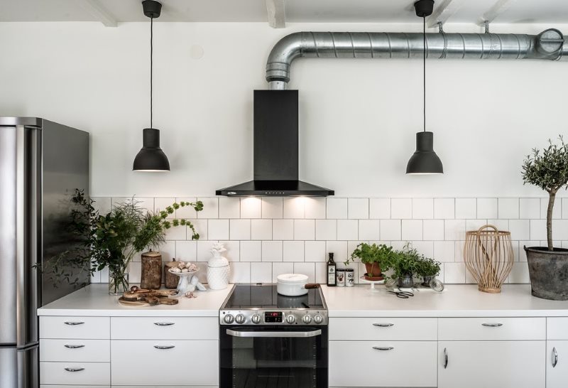 Ventilatore nero dell'estrattore su una parete bianca di cucina scandinava