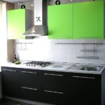 Una semplice cucina grigio-nera sembra più luminosa e più originale con elementi di colore verde