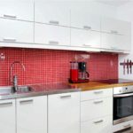 Cucina bianca e grembiule rosso con mosaico