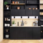 Design impeccabile di una piccola cucina in un colore scuro con un auricolare a layout lineare