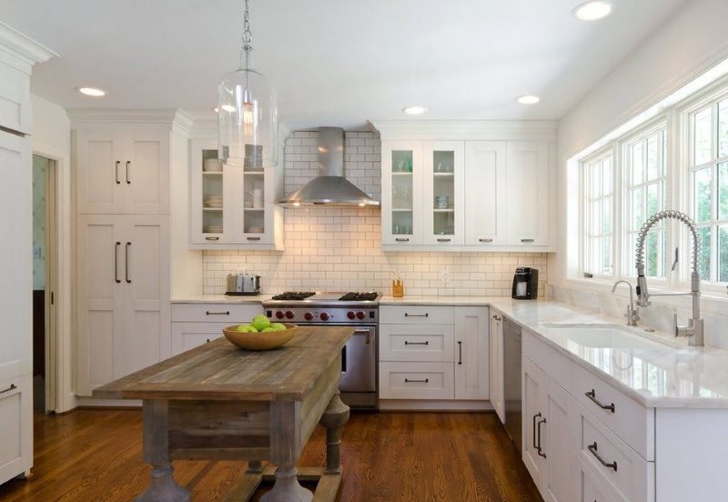 Wooden table in the kitchen with white furniture