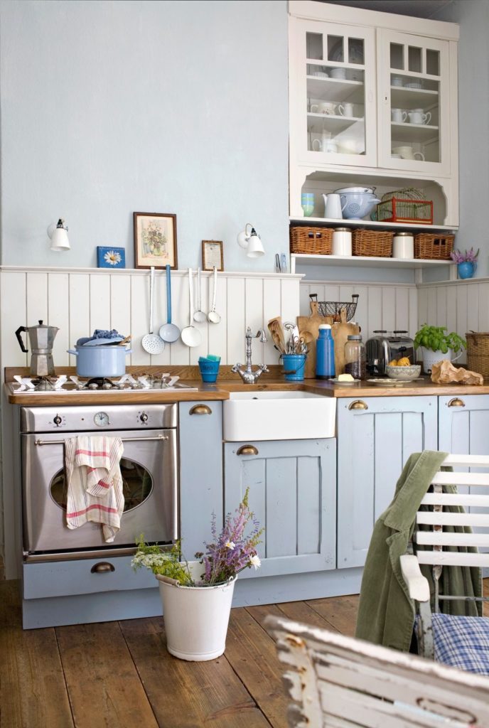 Rustic kitchen with light blue furniture.