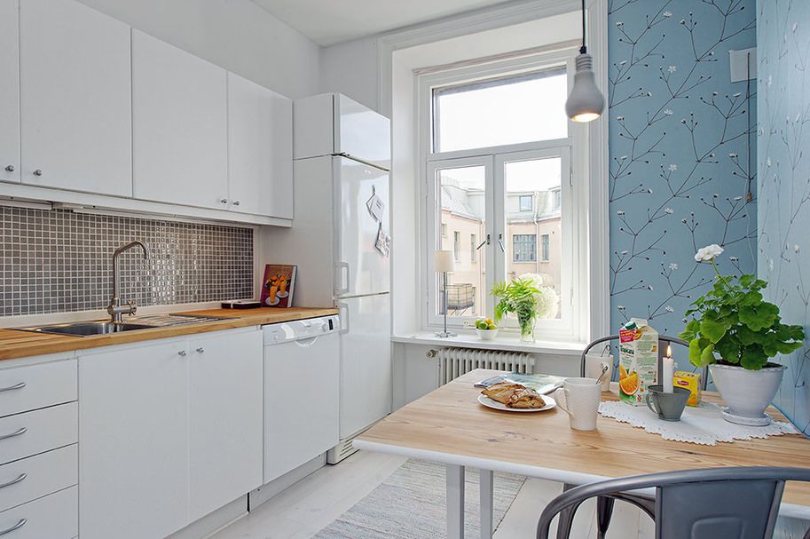 Kitchen interior with blue wallpaper and a white fridge