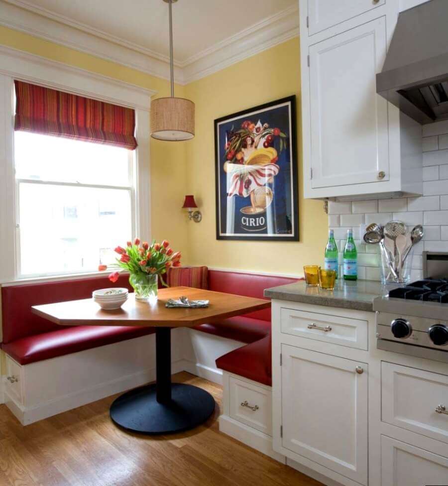 Compact kitchen corner in front of the window with a Roman curtain