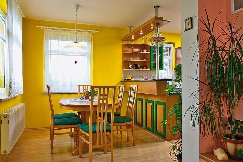 Mur jaune à l'intérieur de la cuisine avec une barre de petit déjeuner