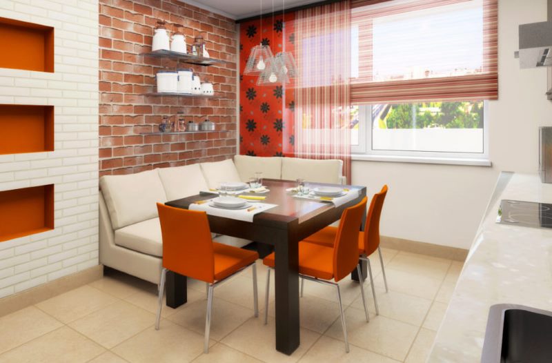 Chaises orange dans la salle à manger de la cuisine avec canapé.