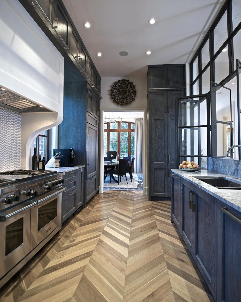 Pavimento in parquet in una cucina stretta con un set blu