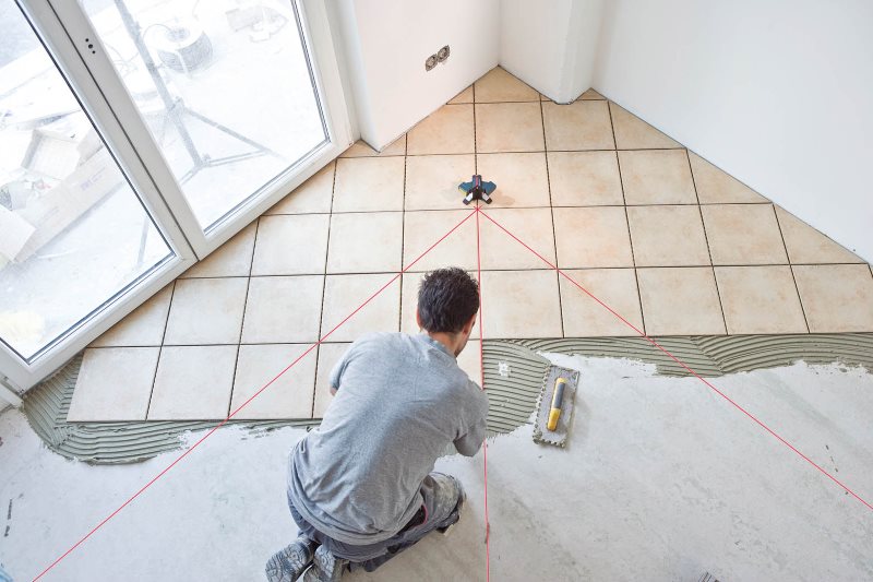 Pose de carreaux de céramique sur le sol de la cuisine