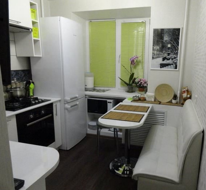 A narrow sofa in the kitchen of Khrushchev with a refrigerator by the window