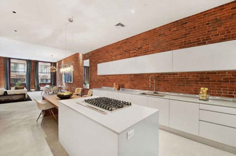 Muro di mattoni in cucina con soffitto bianco.