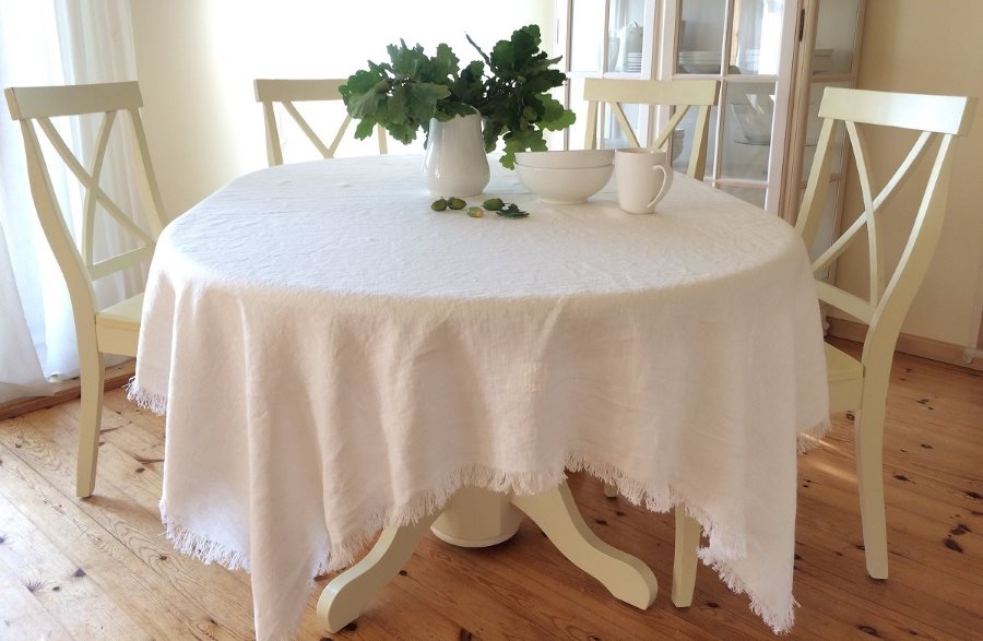 Nappe blanche avec frange sur une table en bois