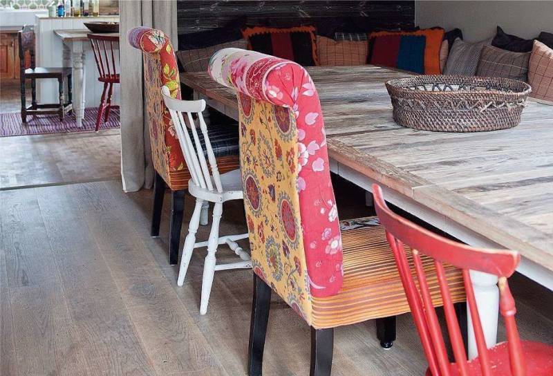 Différentes chaises dans la salle à manger de la cuisine-salon de style champêtre