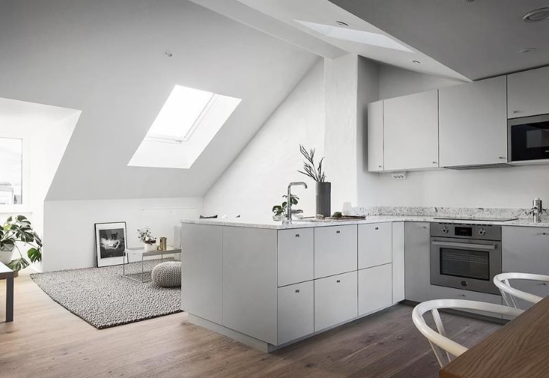 Cuisine blanche dans le grenier d'une maison privée dans un style minimaliste