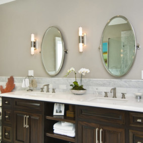 Two oval mirrors on the wall in the bathroom