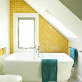 Salle de bain carrelée jaune avec plafond biseauté