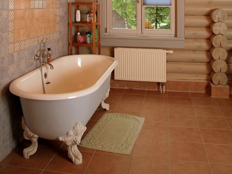 Vasca da bagno con zampe forgiate sul pavimento in ceramica