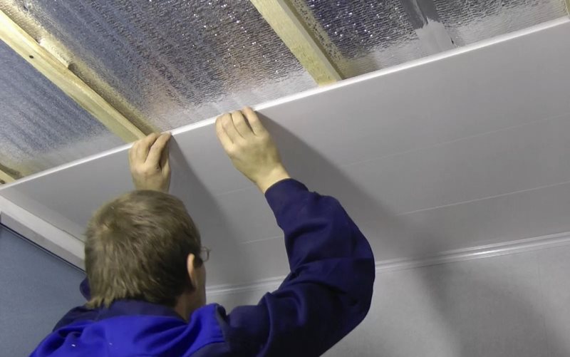 Regolazione dei pannelli di plastica durante l'installazione di un soffitto senza soluzione di continuità