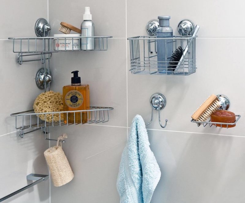 Metal shelves with suction cups on the tiled bathroom wall