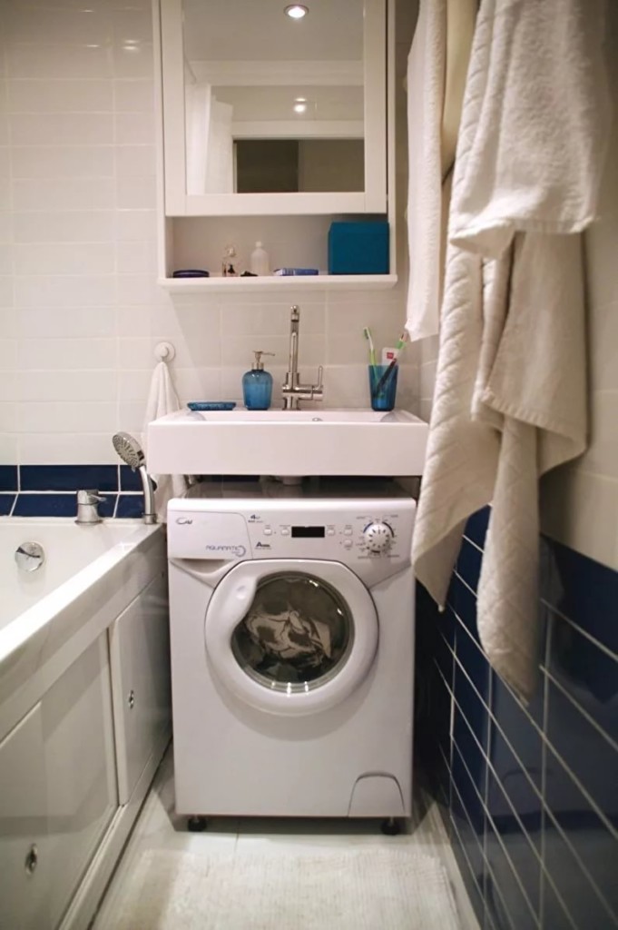 White washing machine under the porcelain sink