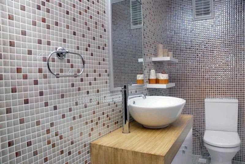 Di fronte alle pareti della toilette con mosaico di vetro