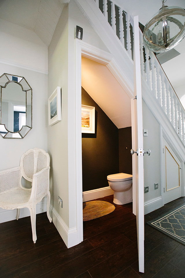 Toilette sous la volée d'escalier dans une maison en bois