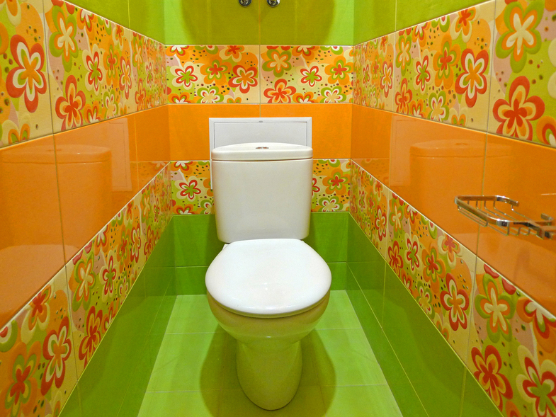 Toilettes blanches dans les toilettes avec des carreaux aux couleurs vives