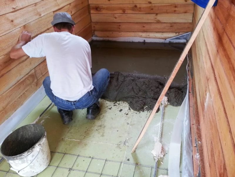 Le dispositif d'un oreiller en béton sur le sol de la salle de bain dans une maison en bois