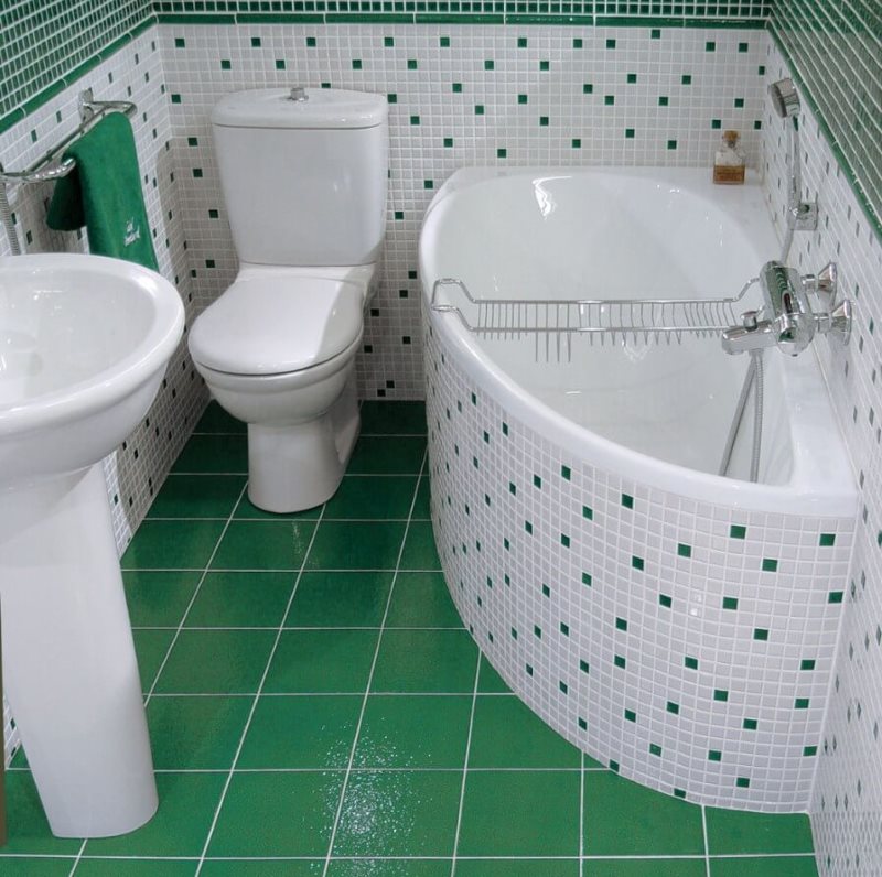 Green tile on the floor of a small bathroom