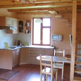 Cucina rurale sotto le scale di una casa di legno