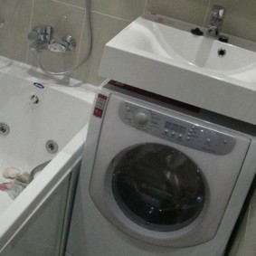 Lavabo au dessus du lave-linge dans la salle de bain sans WC