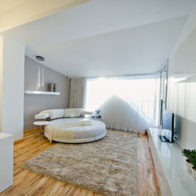 bedroom with a round bed by the window