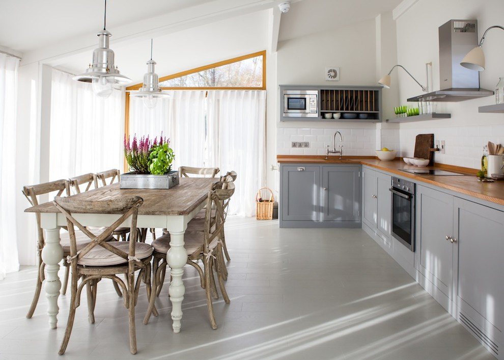 Murs blancs dans le salon-cuisine avec une table en bois