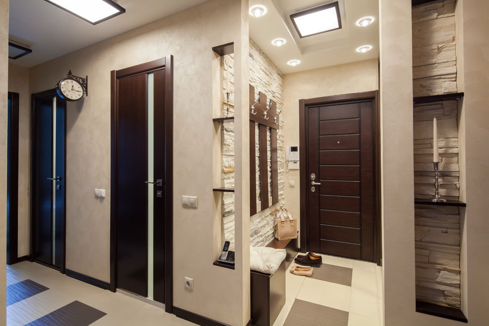 Bright corridor of the apartment with a dark entrance door