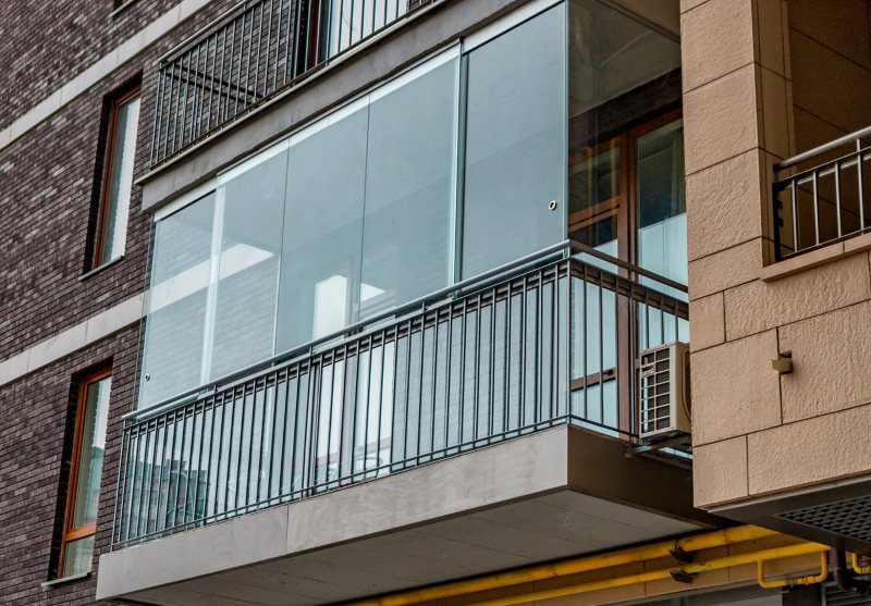 Balcon vitré sur la façade d'un immeuble à plusieurs étages