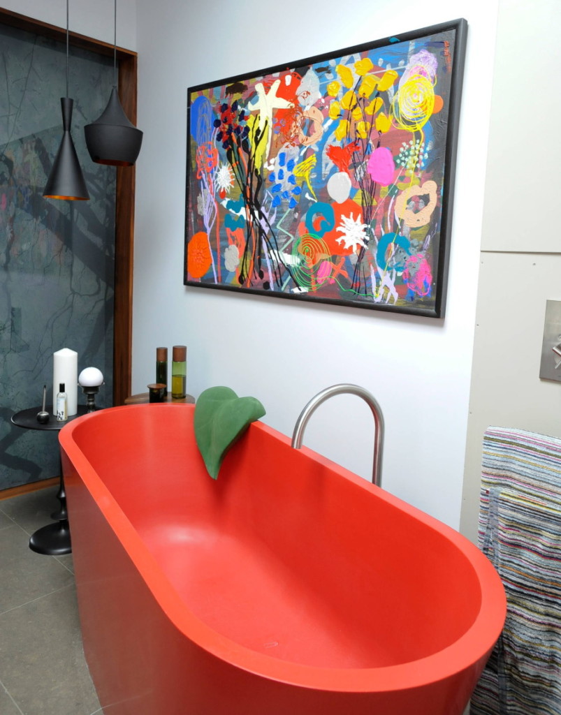 Red matte acrylic bathtub in a small room