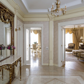 A table with curly legs in front of a mirror in the lobby